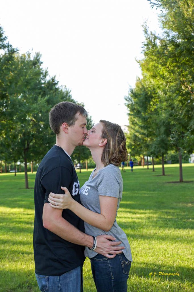 Engaged couple kissing in the park