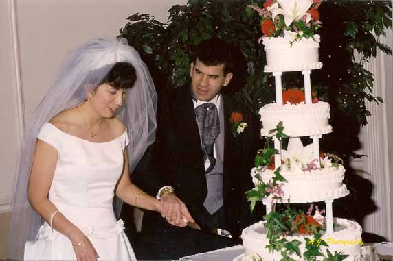 Bride and groom preparing to cut their wedding cake
